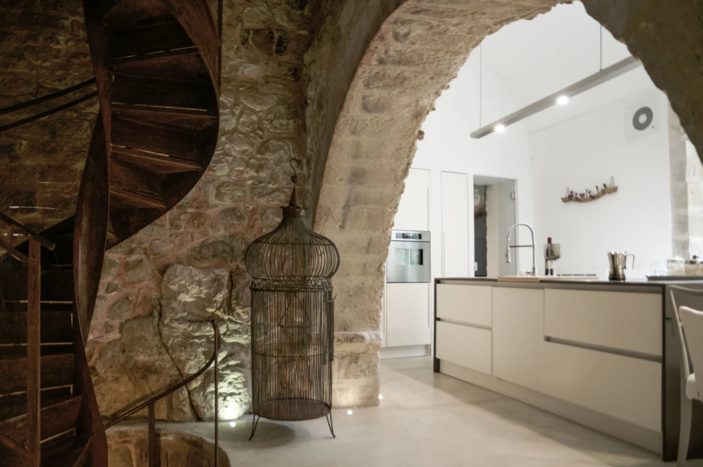 A fully-equipped modern kitchen and an stunning old spiral staircase
