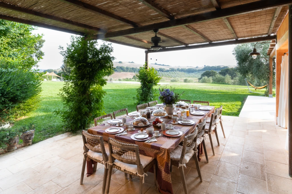Overdekt terras met uitzicht op de tuin en het Toscaanse landschap