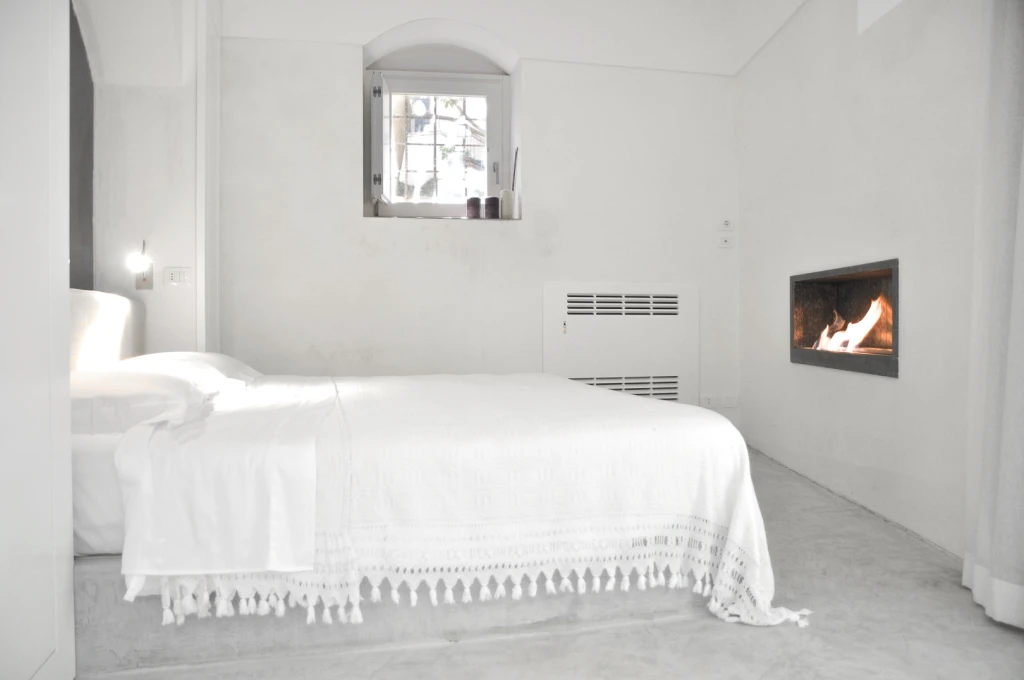 The bedroom is a sanctuary, light and breezy in summer and warm and cozy in winter with a small fire place at the foot of the bed